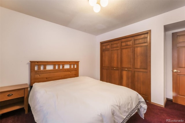 bedroom featuring dark colored carpet and a closet