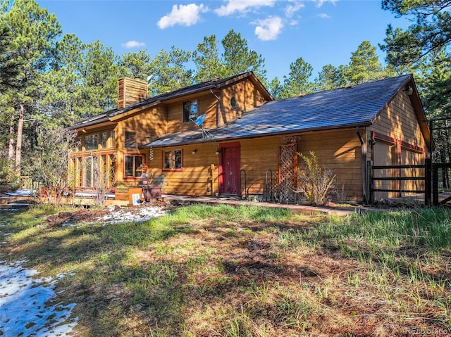 back of house featuring a chimney