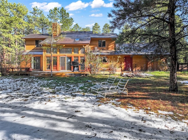 back of property featuring a deck and a chimney