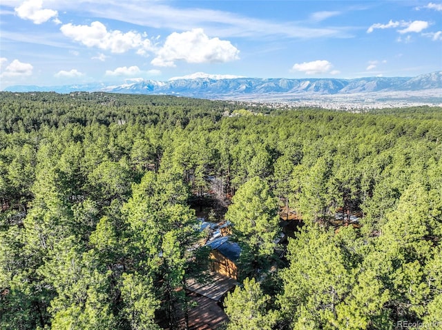 bird's eye view of a heavily wooded area and a mountainous background