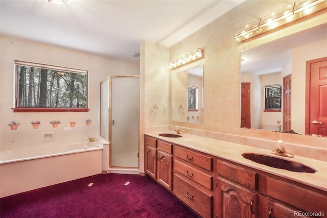 full bath with a stall shower, a bath, double vanity, and carpet floors