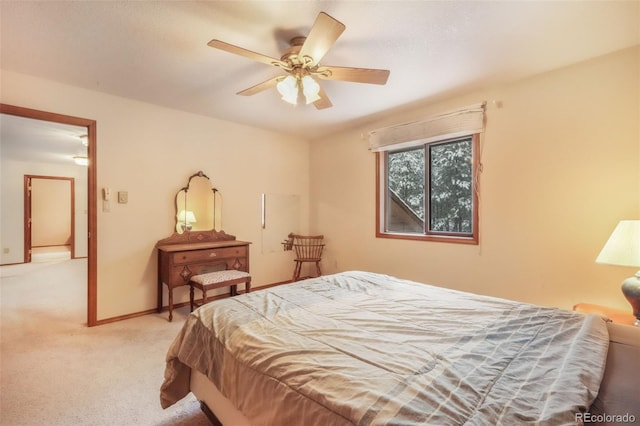 bedroom with light carpet, ceiling fan, and baseboards