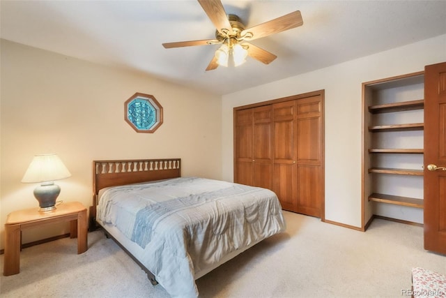 bedroom featuring light carpet, ceiling fan, a closet, and baseboards