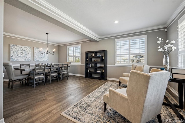 living area featuring dark wood-style floors, baseboards, ornamental molding, and an inviting chandelier