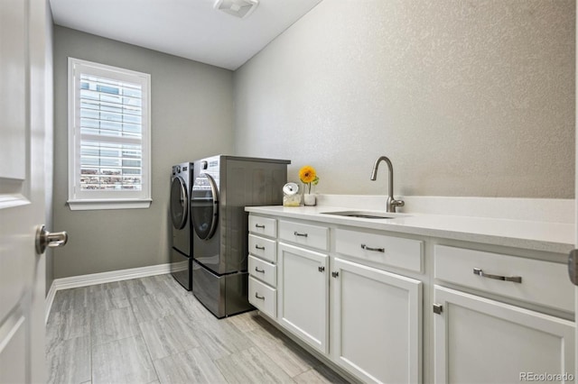 laundry room featuring separate washer and dryer, a sink, visible vents, baseboards, and cabinet space