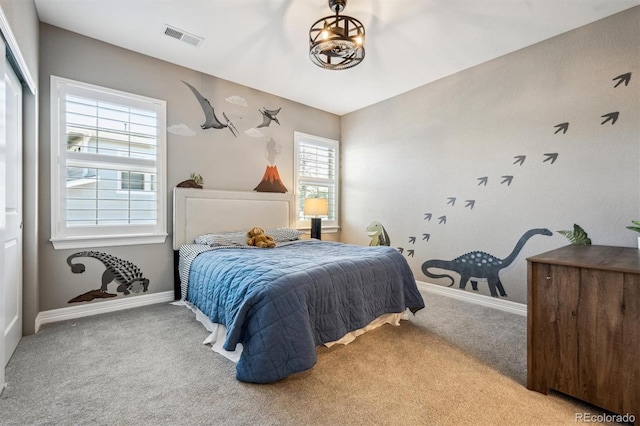 bedroom featuring baseboards, visible vents, and light colored carpet