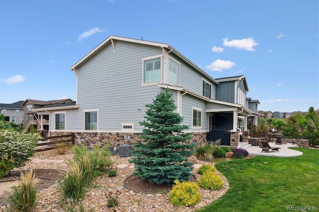 21854 Tyrolite Ave, Parker, CO 80138 - view of side of property featuring stone siding, a patio area, a fire pit, and central AC unit