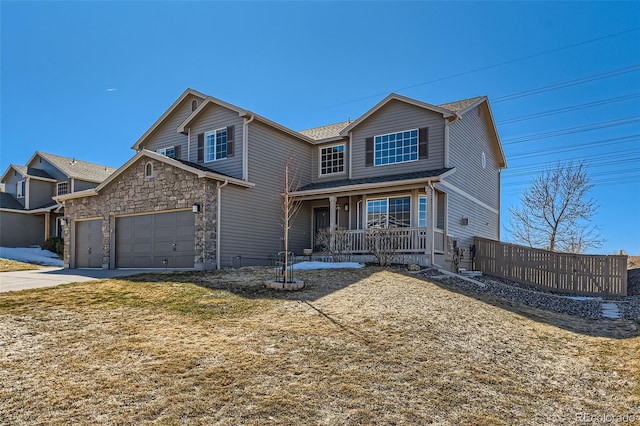 traditional home with stone siding, covered porch, and concrete driveway