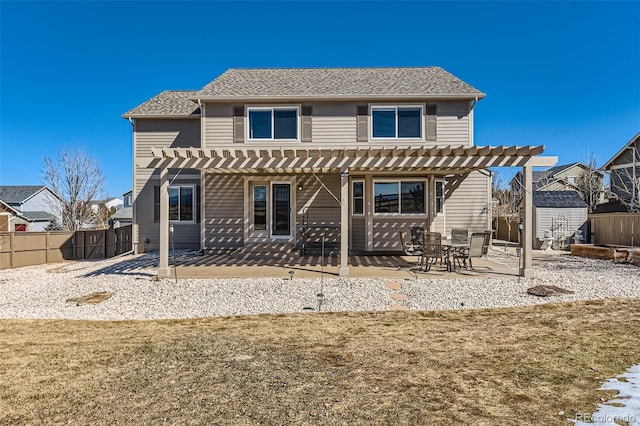 rear view of property featuring an outbuilding, a storage unit, a patio, and a pergola