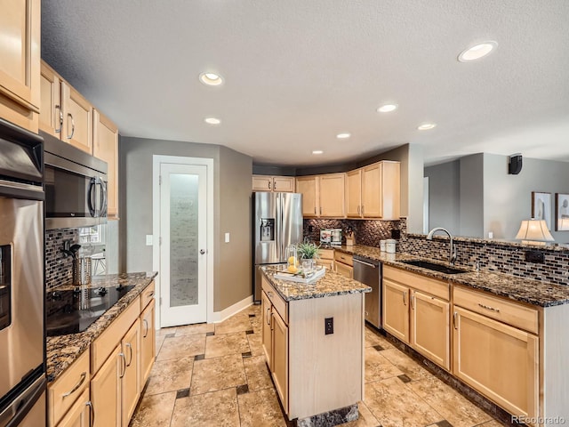 kitchen featuring stainless steel appliances, a center island, a sink, and light brown cabinetry