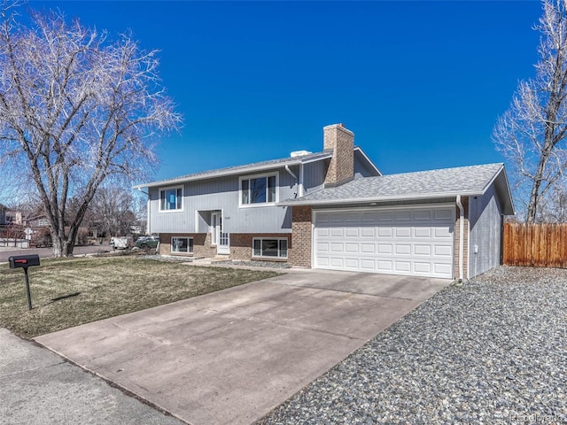 split foyer home with a garage, brick siding, fence, driveway, and a chimney