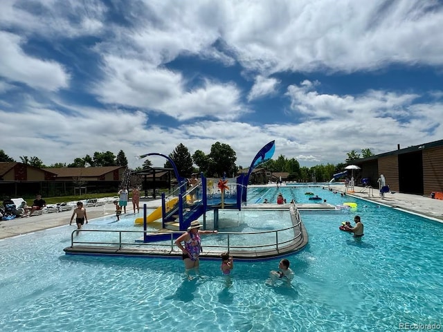 view of swimming pool with a water play area and playground community