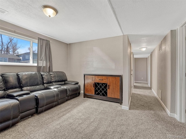 living room with baseboards, carpet, visible vents, and a textured ceiling