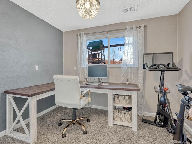 office space with a textured ceiling, carpet floors, and visible vents