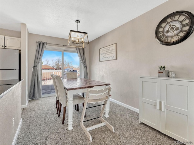 dining area with a chandelier, light colored carpet, and baseboards