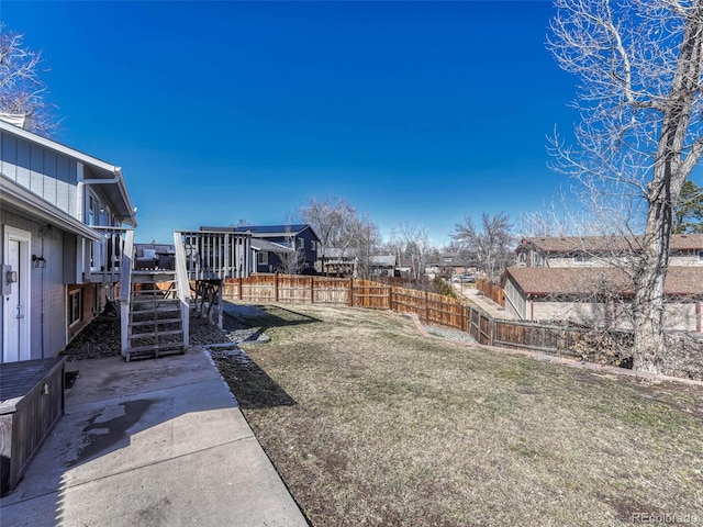 view of yard with a deck, stairway, and fence