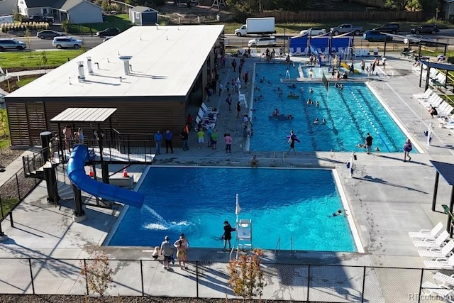 pool featuring a water slide and fence