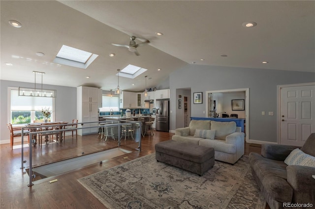6760 S Depew St, Littleton, CO 80128 - living area with vaulted ceiling, a skylight, a ceiling fan, dark wood-style flooring, and recessed lighting