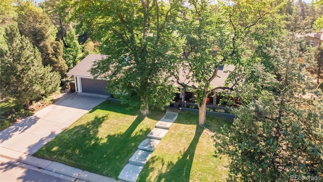 6760 S Depew St, Littleton, CO 80128 - view of front of home with concrete driveway, a front lawn, an attached garage, and a view of trees