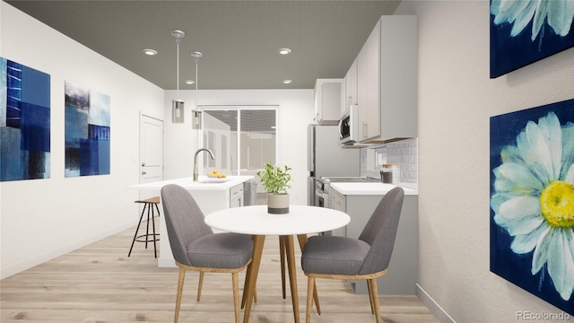 dining area with sink and light wood-type flooring