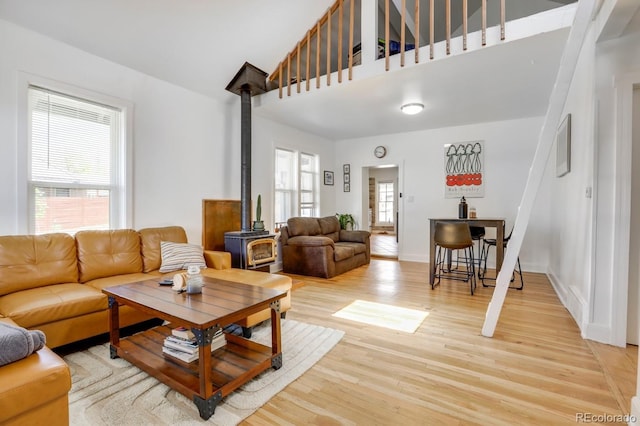 3000 S Sherman St, Englewood, CO 80113 - living area featuring a wood stove, light wood-style flooring, healthy amount of natural light, and a high ceiling