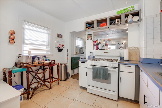 3000 S Sherman St, Englewood, CO 80113 - kitchen featuring white gas range, white cabinets, open shelves, and light tile patterned floors