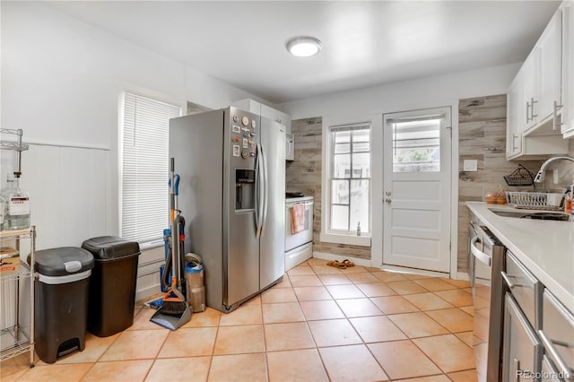 3000 S Sherman St, Englewood, CO 80113 - kitchen with appliances with stainless steel finishes, a sink, light countertops, light tile patterned floors, and white cabinets