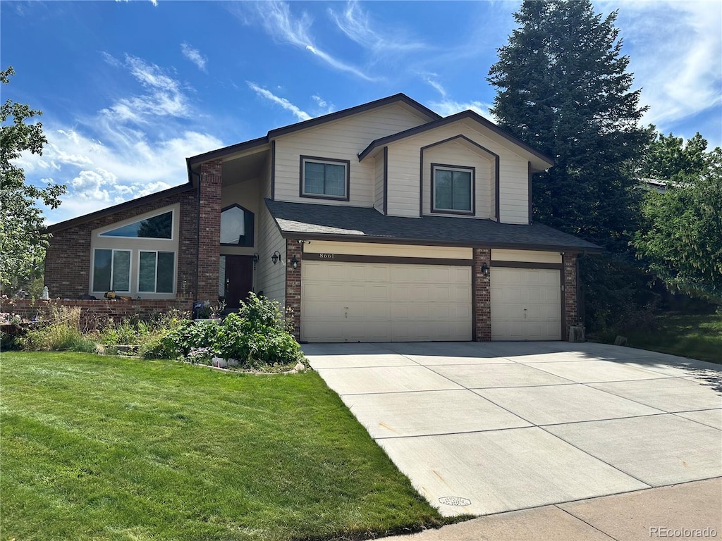 8661 Snowbrush Ln, Highlands Ranch, CO 80126 - view of front of home with an attached garage, brick siding, and concrete driveway
