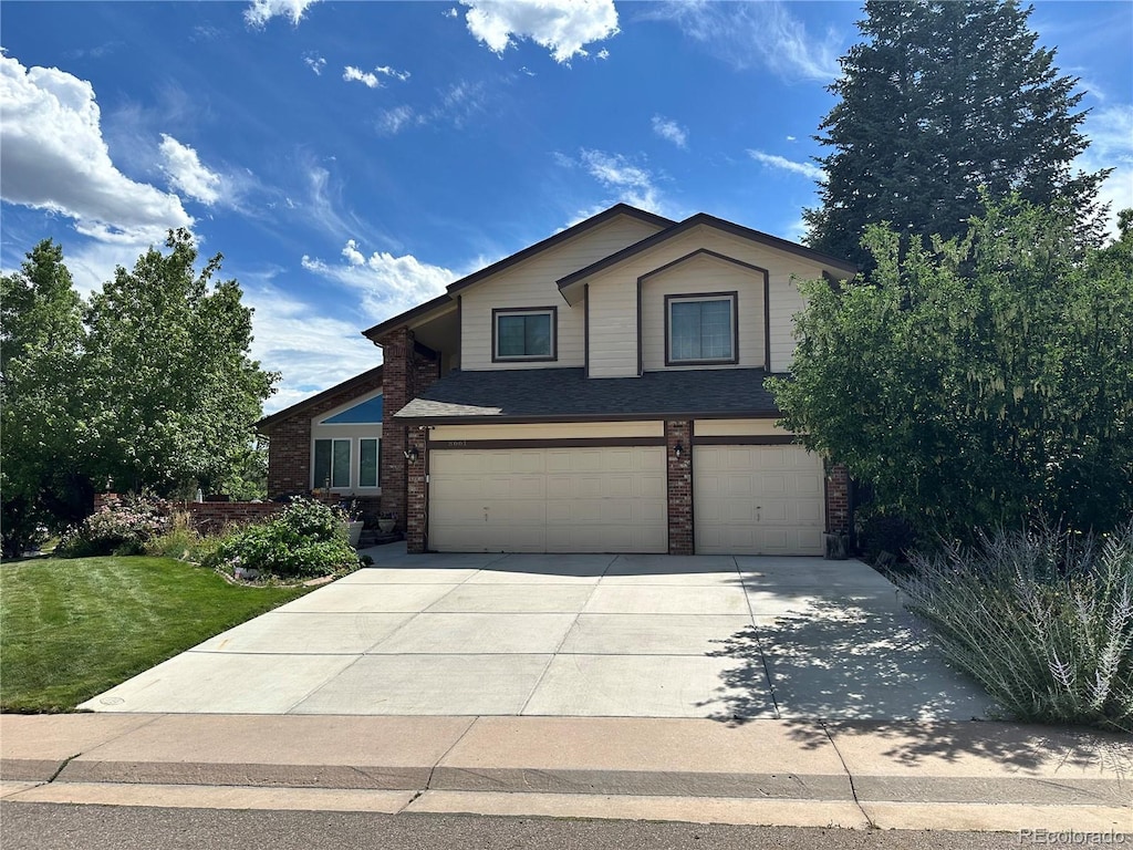 8661 Snowbrush Ln, Highlands Ranch, CO 80126 - view of front of property with a garage, concrete driveway, brick siding, and a front lawn