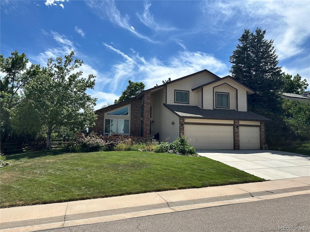 8661 Snowbrush Ln, Highlands Ranch, CO 80126 - view of front of home featuring a garage, brick siding, concrete driveway, and a front yard
