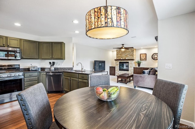 dining room with a fireplace, dark wood finished floors, ceiling fan, and recessed lighting