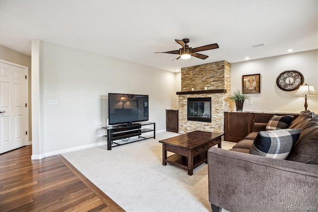 living room featuring ceiling fan, a fireplace, wood finished floors, recessed lighting, and baseboards