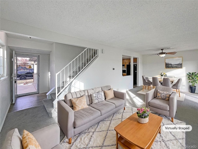 living room with ceiling fan and a textured ceiling