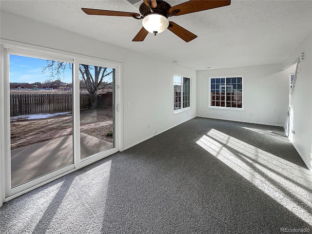 empty room with dark carpet and a textured ceiling