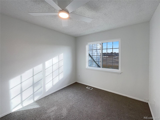 carpeted empty room with ceiling fan and a textured ceiling