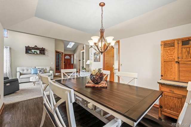 dining space featuring lofted ceiling, dark wood-style flooring, and an inviting chandelier