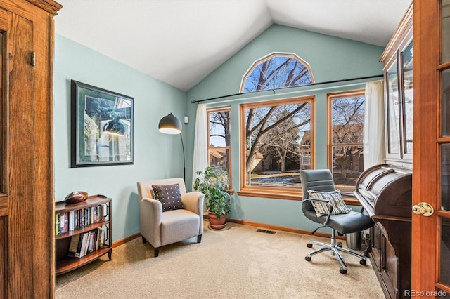 carpeted home office featuring vaulted ceiling