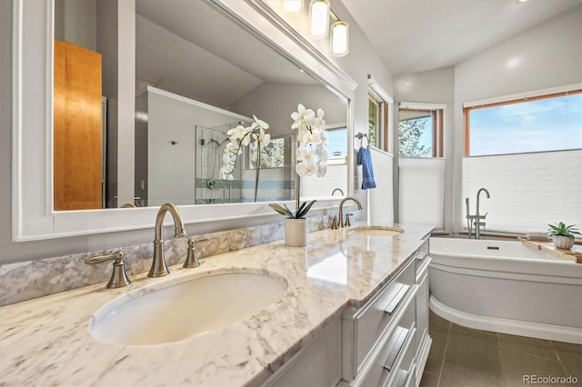 bathroom featuring vanity, tile patterned flooring, vaulted ceiling, and a tub