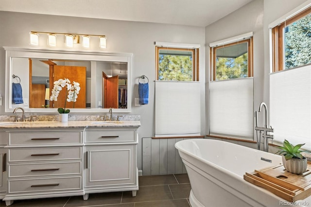 bathroom featuring a tub to relax in, vanity, and tile patterned floors