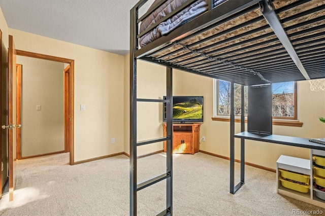 carpeted bedroom featuring a textured ceiling and baseboards