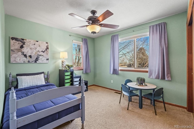 bedroom with multiple windows, light colored carpet, and ceiling fan