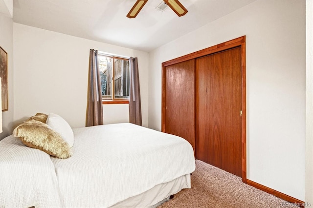 bedroom featuring baseboards, visible vents, a ceiling fan, carpet flooring, and a closet