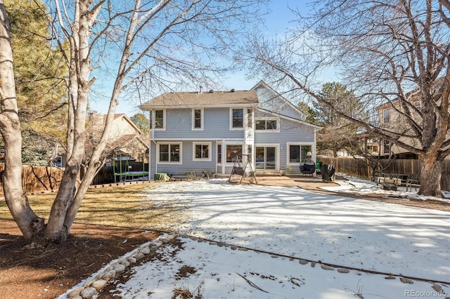 view of front of home with a trampoline, a patio area, and a fenced backyard