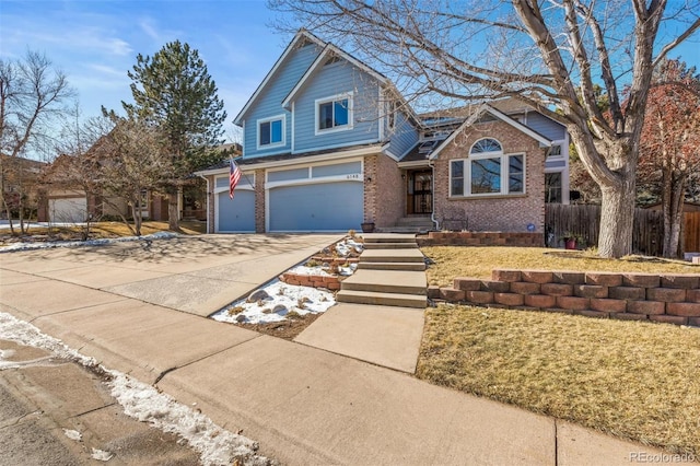 view of front of house featuring driveway, an attached garage, fence, and brick siding