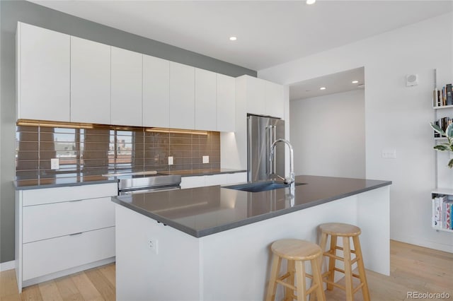 1300 N Ogden St Unit 304, Denver, CO 80218 - kitchen with high end refrigerator, a sink, light wood finished floors, dark countertops, and recessed lighting