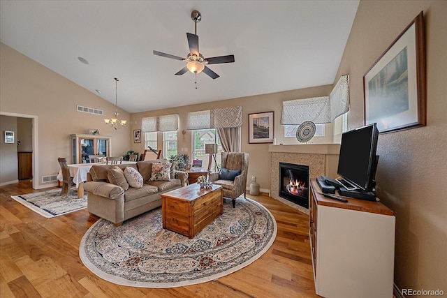 22124 E Euclid Dr, Aurora, CO 80016 - living area with a tile fireplace, light wood-type flooring, a chandelier, ceiling fan, and high vaulted ceiling