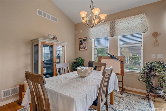 22124 E Euclid Dr, Aurora, CO 80016 - dining area with light wood-style flooring, a chandelier, and high vaulted ceiling