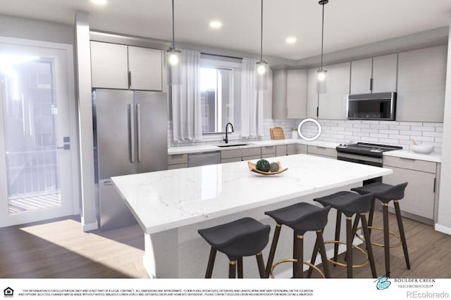 1593 W 166th Ave, Broomfield, CO 80023 - kitchen with stainless steel appliances, a sink, a kitchen breakfast bar, light wood-style floors, and a kitchen island