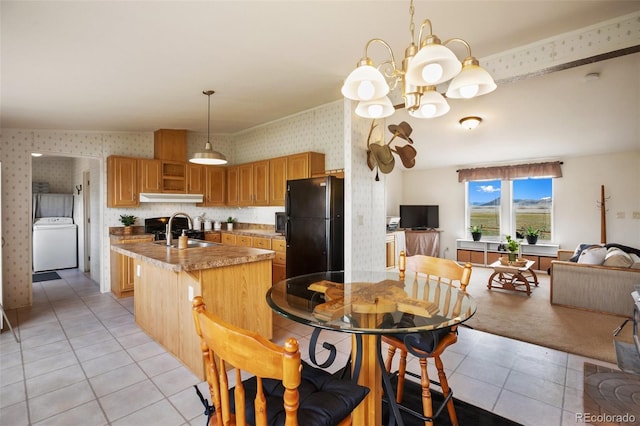 463 Snowshoe Ln, Lake George, CO 80827 - kitchen featuring freestanding refrigerator, washer / clothes dryer, wallpapered walls, under cabinet range hood, and a sink