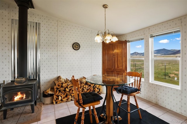 463 Snowshoe Ln, Lake George, CO 80827 - dining area featuring a wood stove, wallpapered walls, light tile patterned floors, a chandelier, and a mountain view
